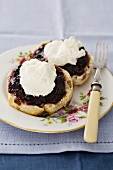 Scones topped with jam and clotted cream
