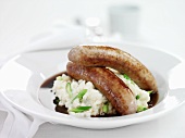 Sausages on a bed of mashed potatoes with spring onions