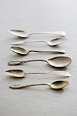 A row of antique silver spoons