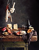 Stillleben mit Wurst, Käse, Oliven, Brot und Wein