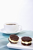 Chocolate biscuits filled with cream and a cup of coffee