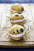 Three Whoopie Pies with blueberries on a wooden board