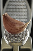 A garlic clove in a garlic press (close-up)