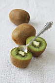 Kiwis, whole and halved, with a spoon
