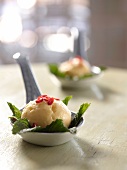 Mango and coconut sorbet with chilli on mint leaves