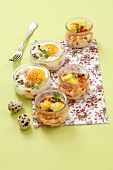 Chicken eggs and quail's eggs in jars baked with peppers and capers