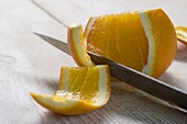 An orange being filleted