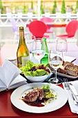 Schweinefilet mit Erbsenpüree, Salat, Brot und Wein