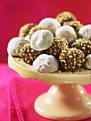 Fudge balls with icing sugar and chopped nuts