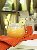 Pear punch in a glass cup on an orange napkin