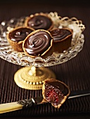 Raspberry cakes with chocolate cream on an elegant cake stand
