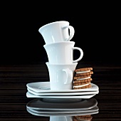 A stack of espresso cups with three espresso biscuits