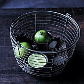 Limes in a cake tin in a bucket