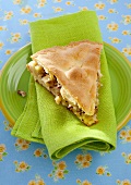 A slice of apple pie with nuts