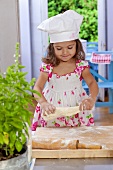 Small girl kneading dough