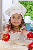 Kleines Mädchen hält zwei Tomaten