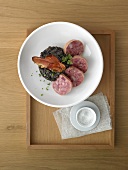 Cotechino on black lentils with South Tyrolean bacon