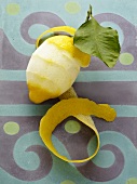 A partially peeled lemon with peel