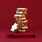 A stack of star shaped cinnamon cookies with red ambiance