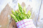 A bunch of green asparagus in a kitchen towel