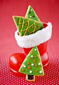Christmas cookies shaped like Christmas trees, some in a Santa boot