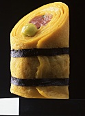 A rolled crepe with tuna fish, wasabi, tied with seaweed
