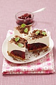 Three slices of cheesecake with cherry jam and chocolate curls