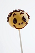 A yellow cake pop with a face