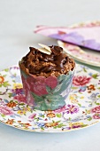 A chocolate cupcake in a paper case printed with flowers
