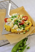Millet and corn cakes with peas, cauliflower and tomatoes