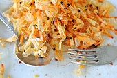 A pile of prawn shells with a fork and a spoon