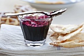 Blueberry jam in a glass bowl with a spoon