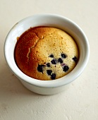 A blueberry muffin in a porcelain ramekin