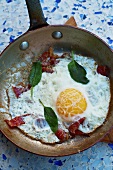 Fried egg with Serano ham and sage in a pan