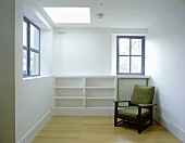 A green upholstered 1950s armchair against a concrete wall in an empty room