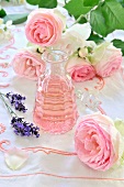 Rose oil, pink roses and lavender flowers