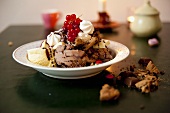 Mixed ice cream with chocolate sauce and blackcurrants