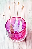 Rock sugar sticks in a pink glass