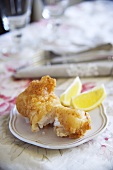 Fried mussels in beer batter with lemon wedges