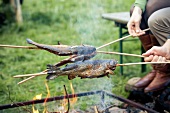 Fish being grilled over a fire
