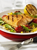 Grilled char on a bed of corn and tomato salad