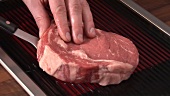 Putting beefsteak on an electric grill