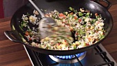 Cooking vegetable rice in a wok