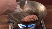 Sautéing chicken in a wok