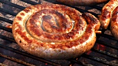 Coiled sausages on a barbecue