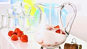 Making strawberry punch: pouring sparkling wine onto strawberries