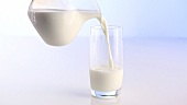 Milch aus der Kanne ins Glas gießen