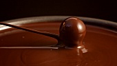Lifting a chocolate out of chocolate couverture