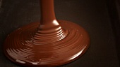 Broken chocolate being made (melted chocolate being poured into a mould)
