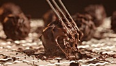 Rolling a chocolate truffle around on a draining rack